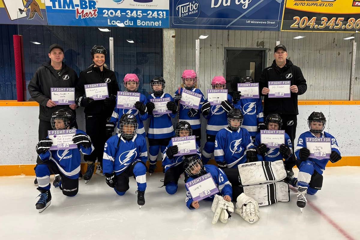 LDB U7 team poses with hockey fights cancer signs